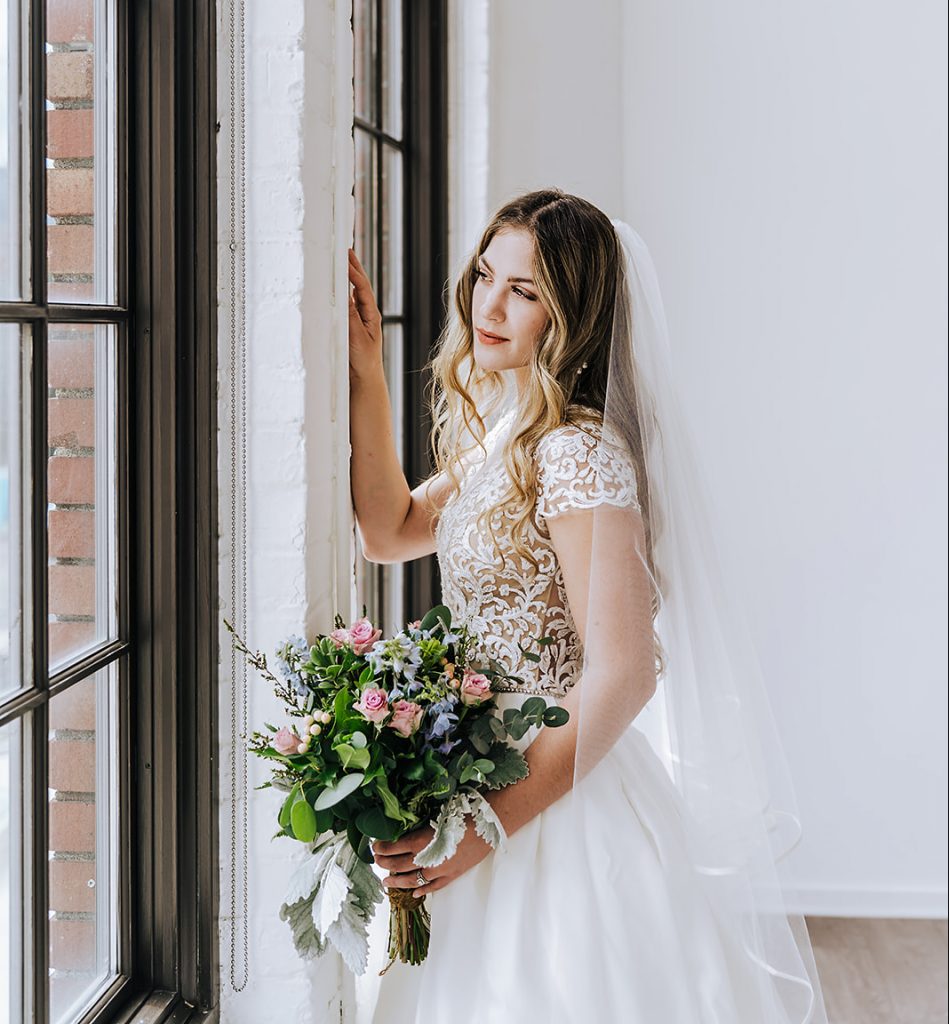 A bride in a lace wedding dress contemplating wedding planning in Portland Oregon